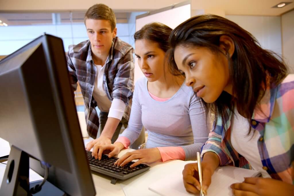 Overspending on Education college students gathered around computer