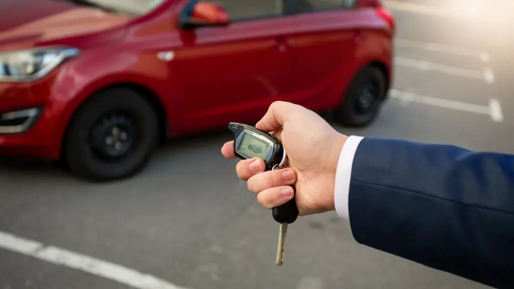 man pressing car alarm on key fob