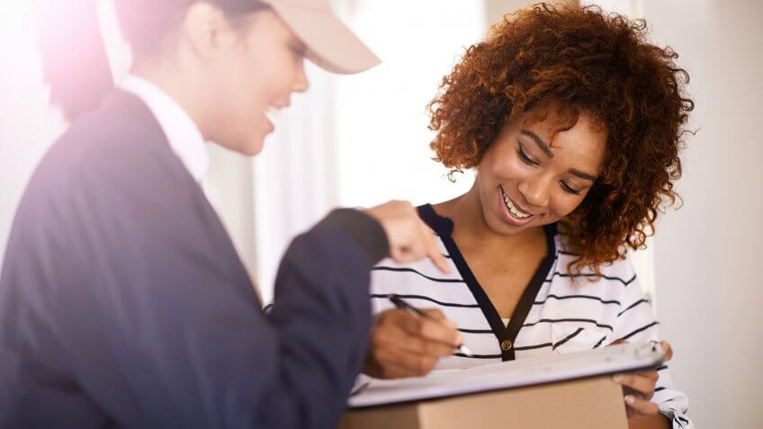 Shot of a courier making a delivery to a smiling customer