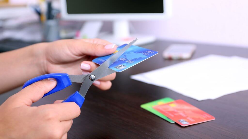 Interest on Credit Cards. someone cutting up their credit card