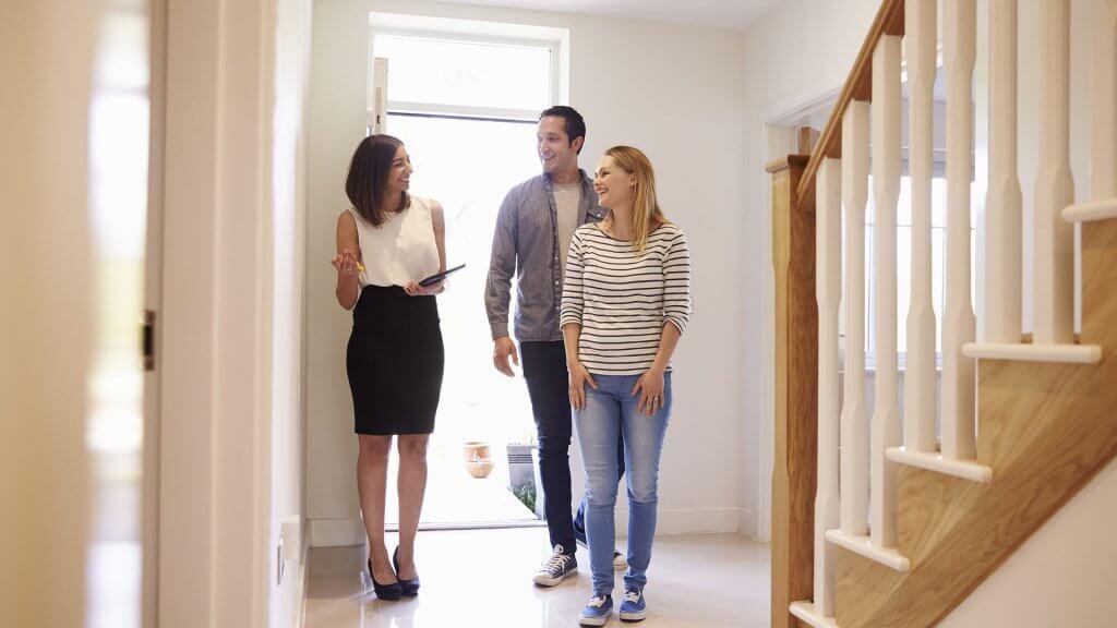 real estate agent showing couple around home