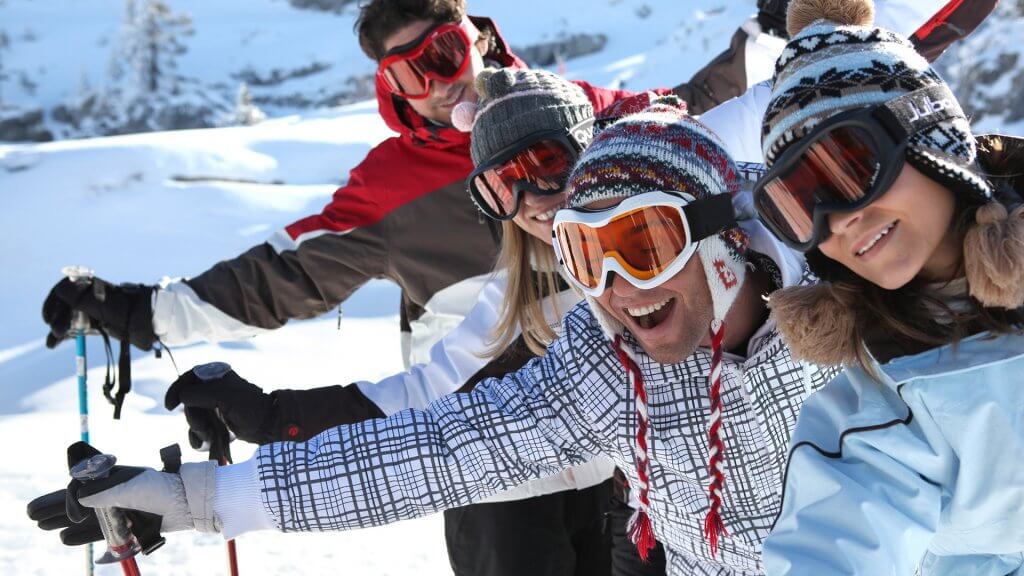 Go during the beginning or end of the ski season. group of four friends skiing