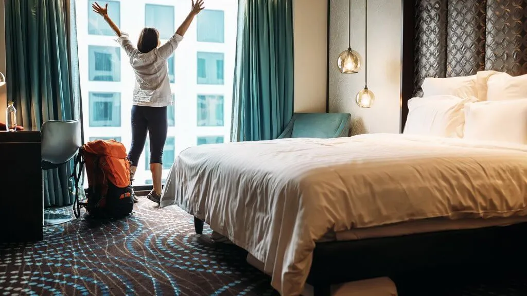 excited woman in hotel room