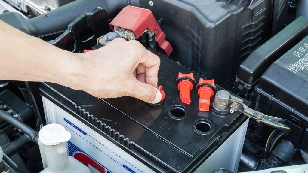 Battery Replacement person checking car battery