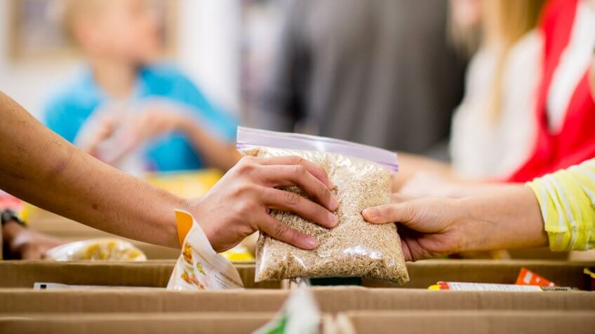Young adults at a community service food bank, preparing boxes with food donations