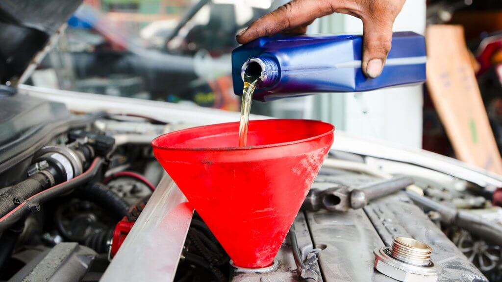 Tune-Up person pouring oil into car