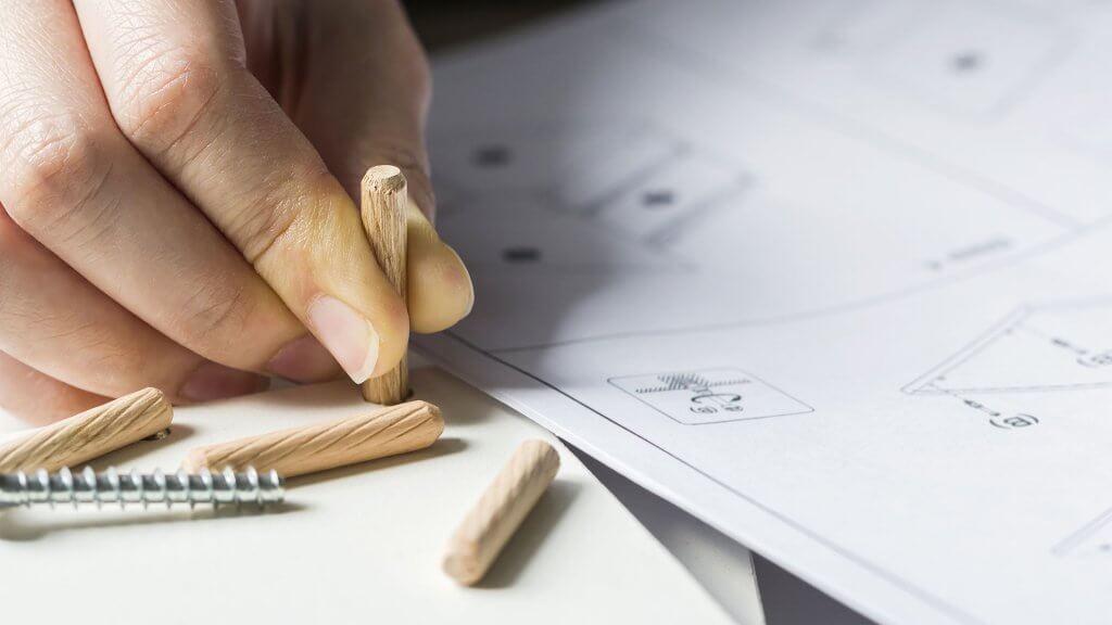 person holding tiny wooden part for ikea product