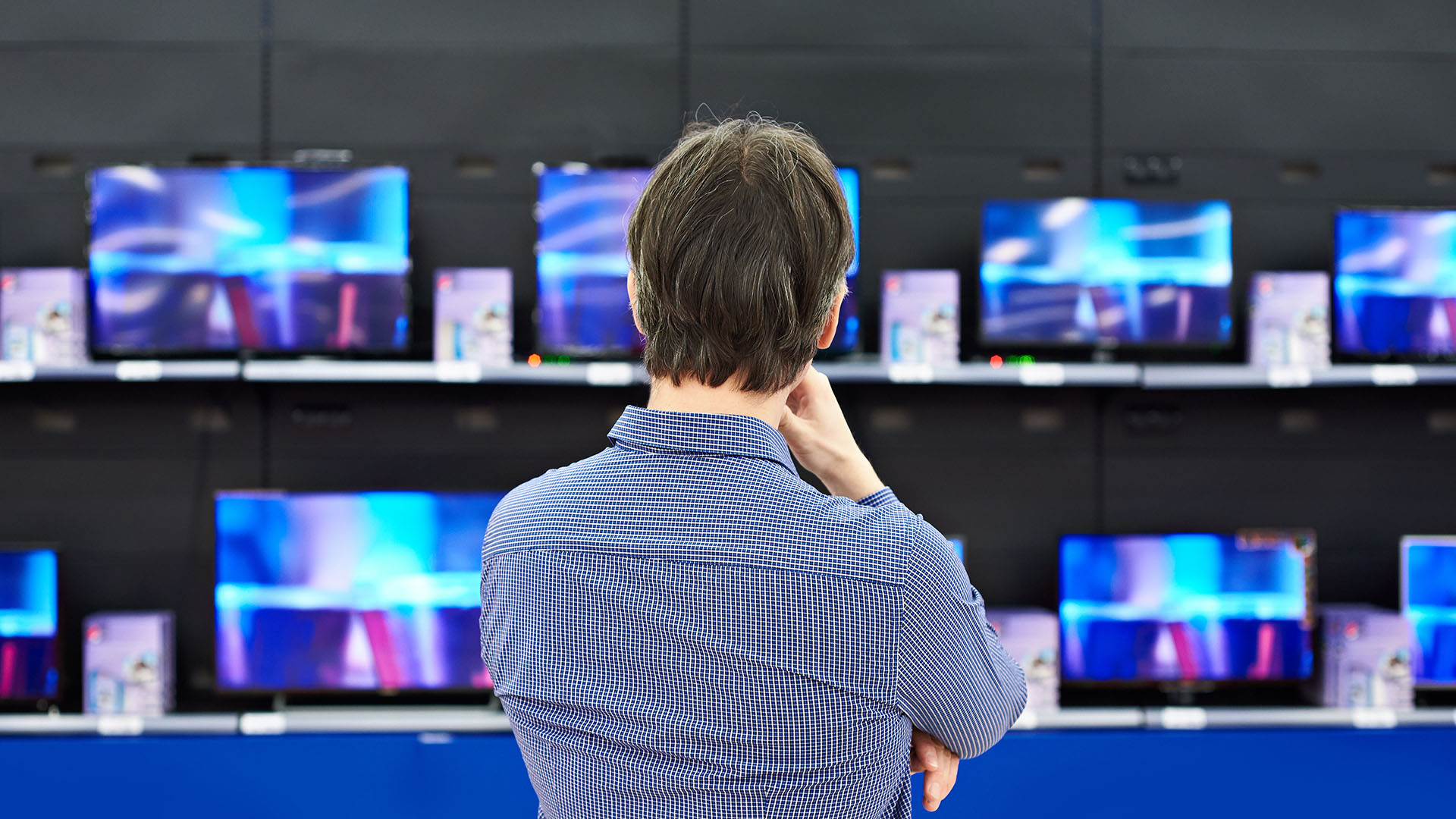 man shopping for TVs