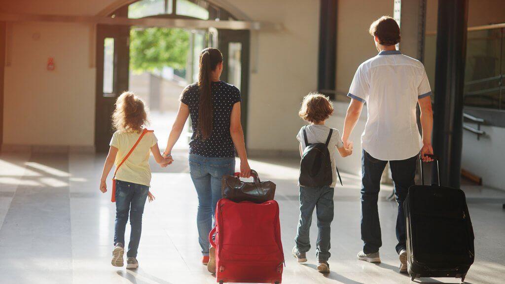 family of four with bags and other luggage