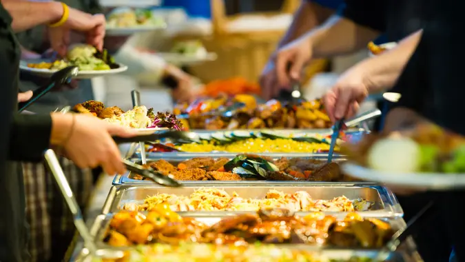 People getting food off a buffet line.