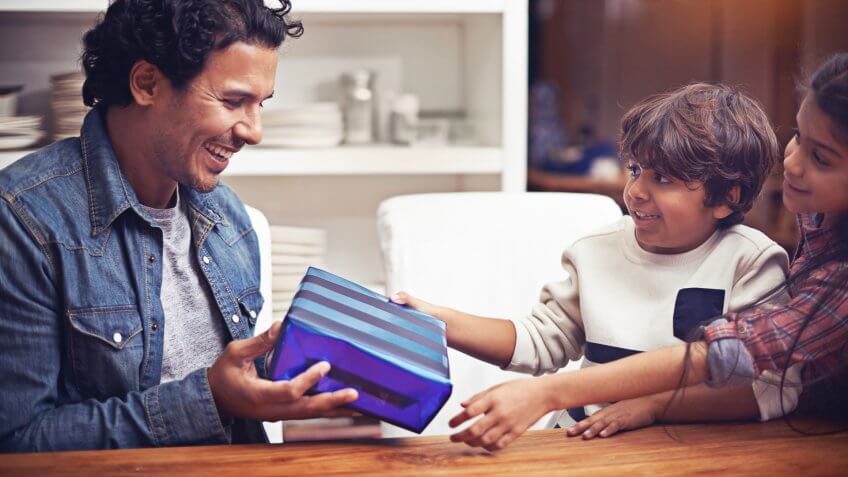 Shot of two children giving their father a gift