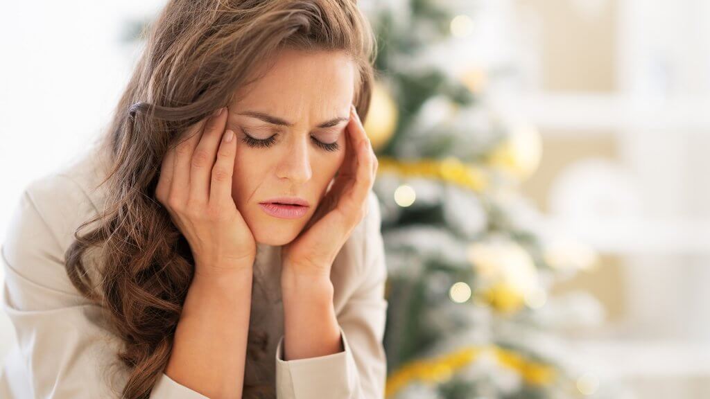 Say goodbye to holiday party-planning stress. stressed woman massaging her head