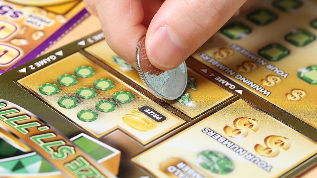 Lottery Tickets. person playing scratch-off lottery ticket