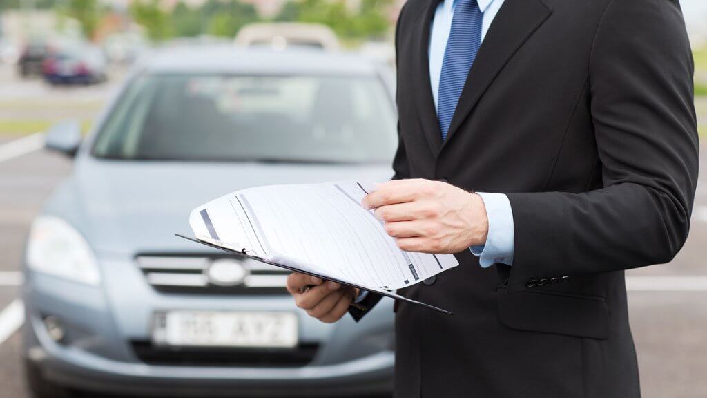 You Need Auto Insurance insurance agent looking over documents