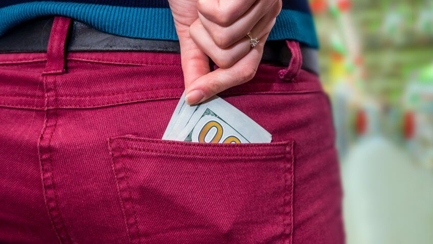 Money in the jeans pocket at supermarket.