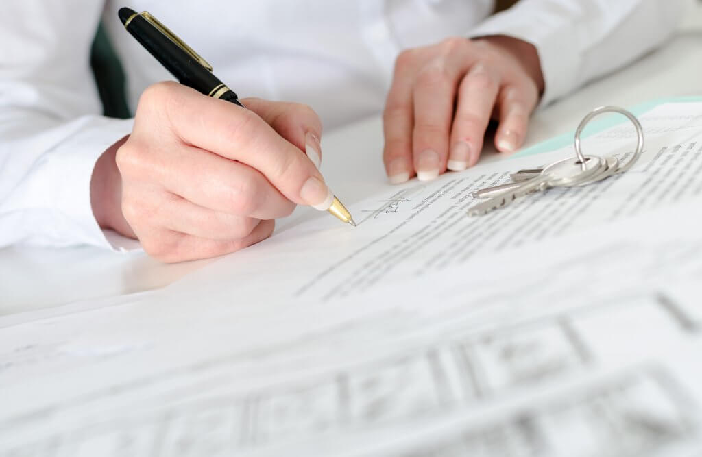 They leverage debt to their advantage hand signing paper with pen