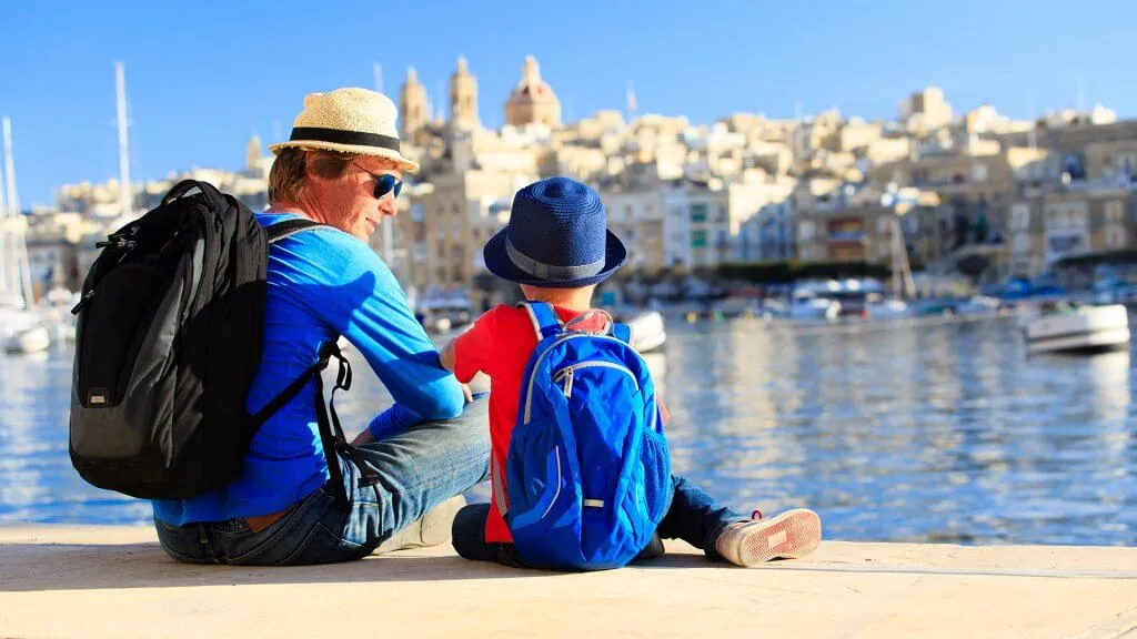 father and son sitting alongside waterfront