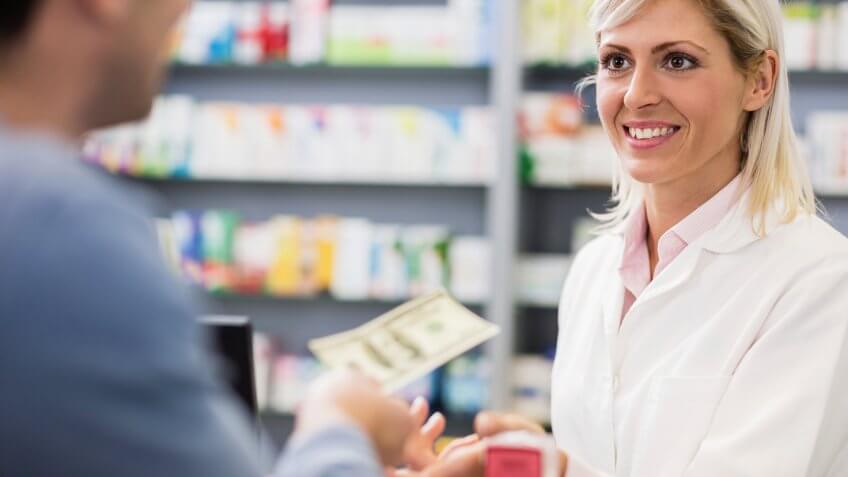 Customer paying with cash in pharmacy.