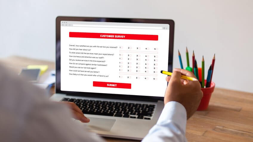 Businessman Filling Survey Form Online on Computer.