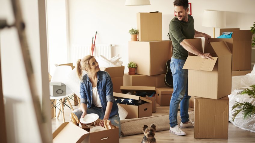 couple with unpacking moving boxes