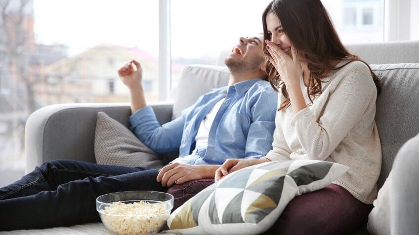 two people laughing on couch