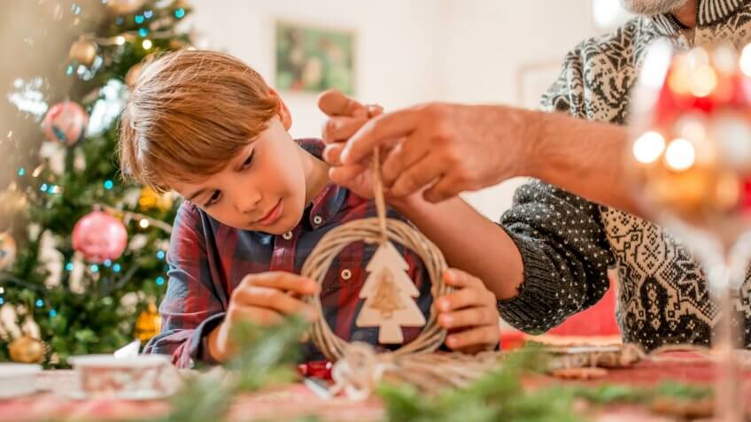 Father and Son Making Homemade Christmas Decoration.