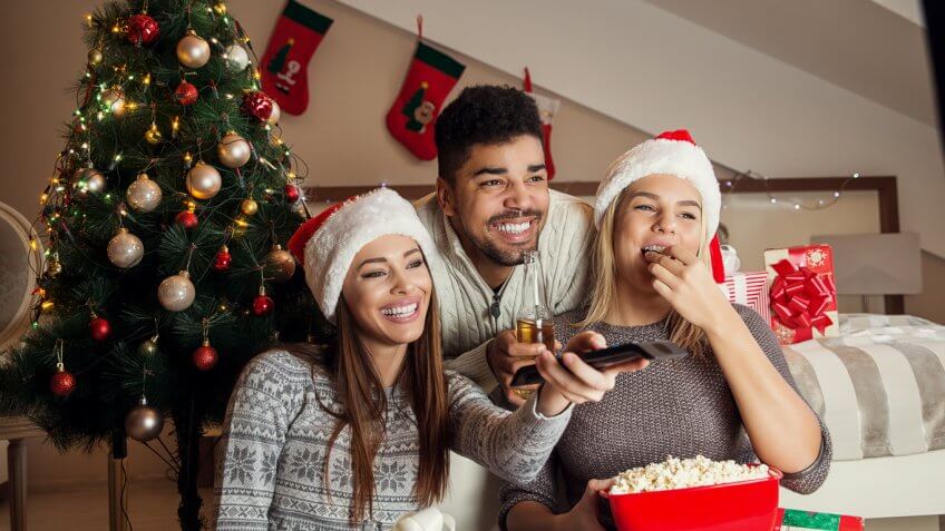 friends in christmas apparel watching tv