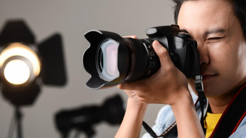 person looking into digital camera taking a photo in an indoor studio
