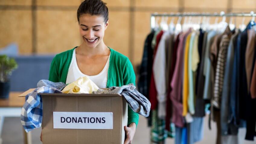 woman carrying a box of donated clothes