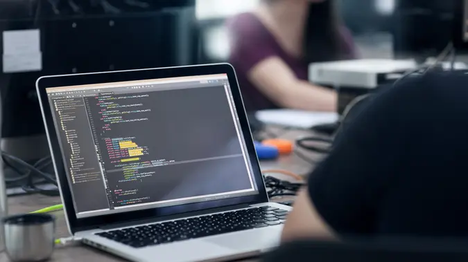 Person looking at code on laptop.
