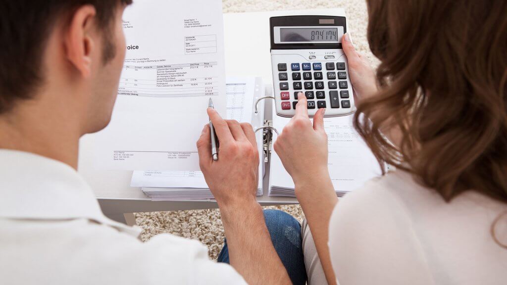 Month 1 Get a Handle on Your Budget man and woman using calculator to determine finances