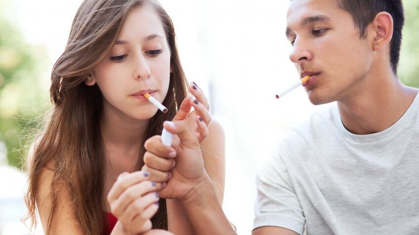 Young man and woman smoking cigarettes