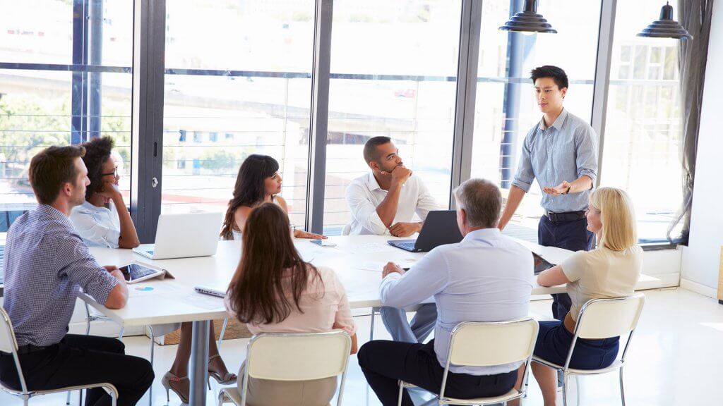 Show Your Value man standing and running a meeting