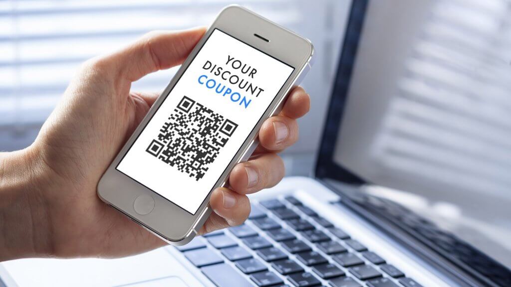 Break Out the Coupons person holding iphone with qr code on screen