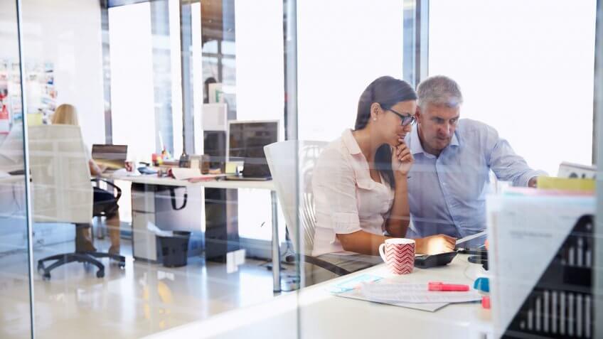 coworkers discussing things at work at their desks