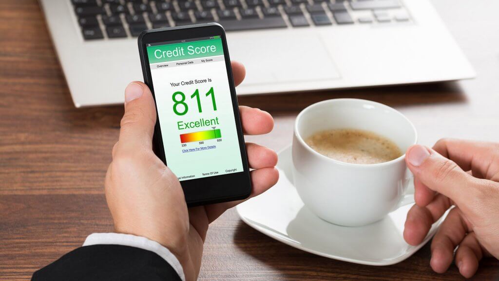 Check Your Credit Report and Score person drinking coffee has an excellent credit score on phone