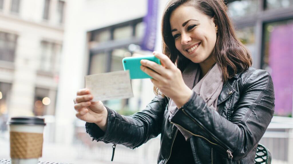 Make Sure You Earn 1300 Each Quarter happy woman taking photo of check