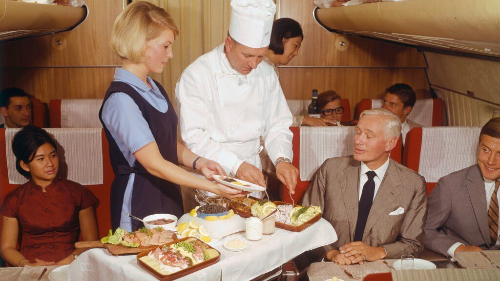 First Class interior of cabin service by chef and air hostess in 1969 First Class interior of cabin service by chef and air hostess in 1969