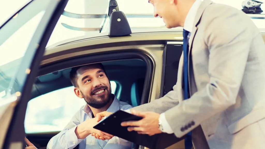 car salesman closing the deal with customer