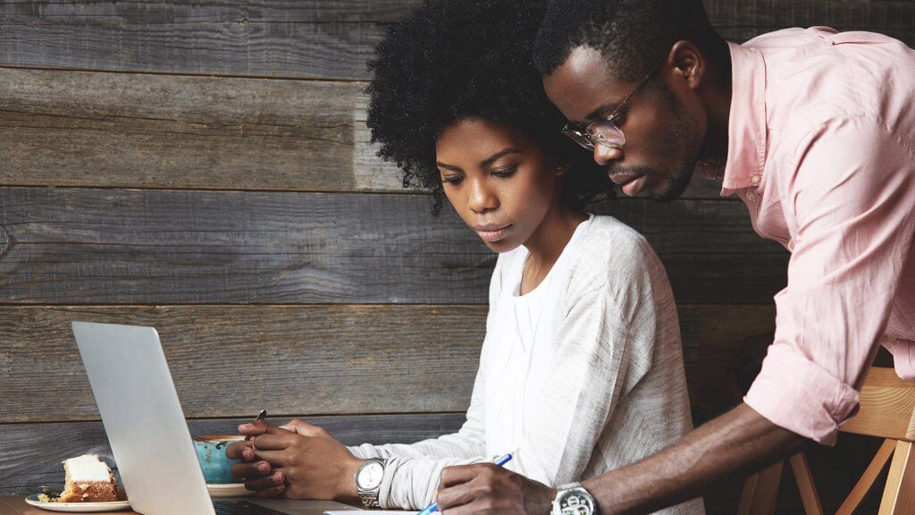 Review Your Investments man writing notes next to a woman