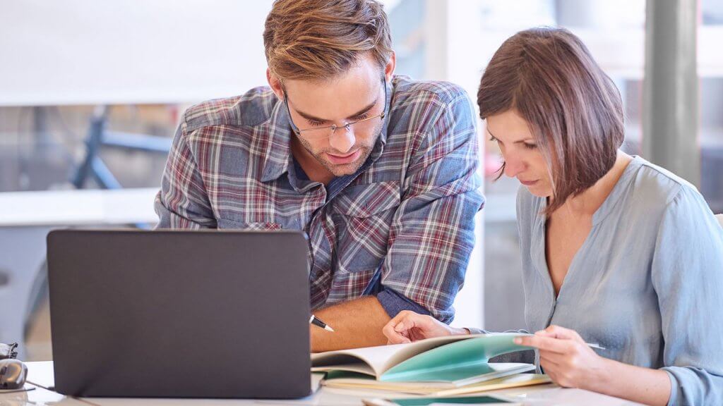 How to Stick to Your Financial Resolutions man and woman reviewing booklet