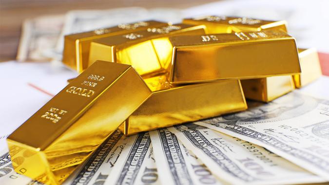 gold blocks on top of hundred dollar bills