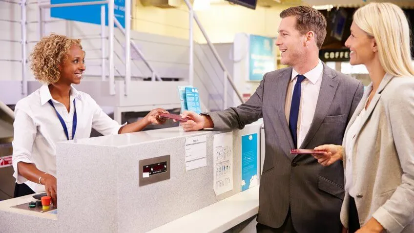 business man and woman checking with airport clerk