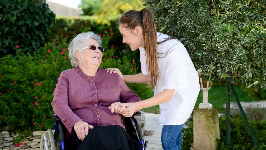 young woman attending elderly woman in a wheelchair