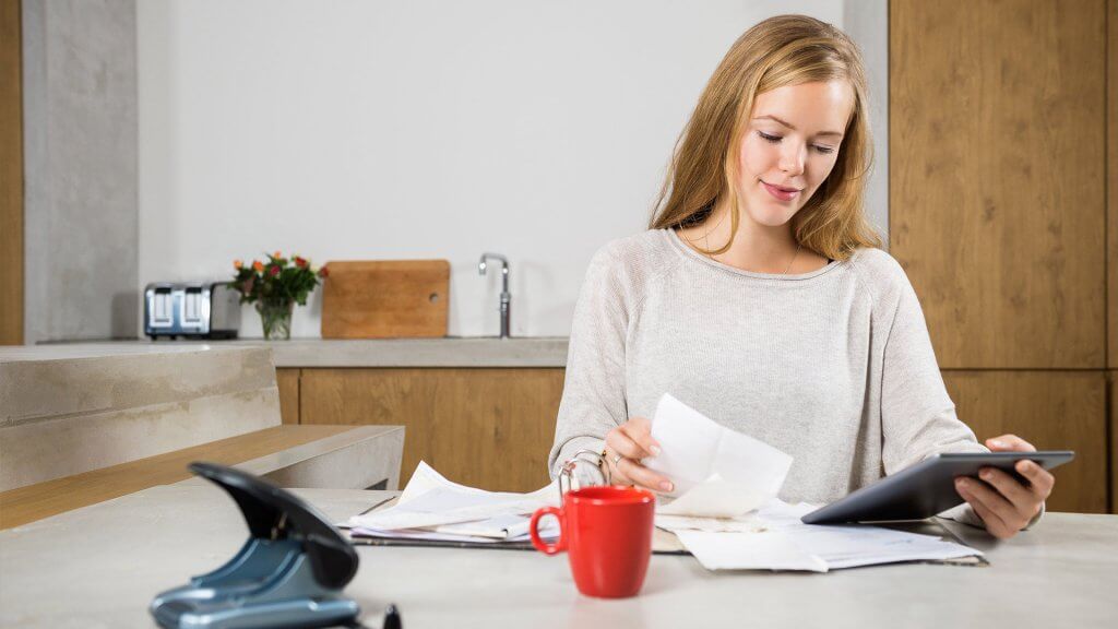 Assess the Damage woman reviewing paperwork at home