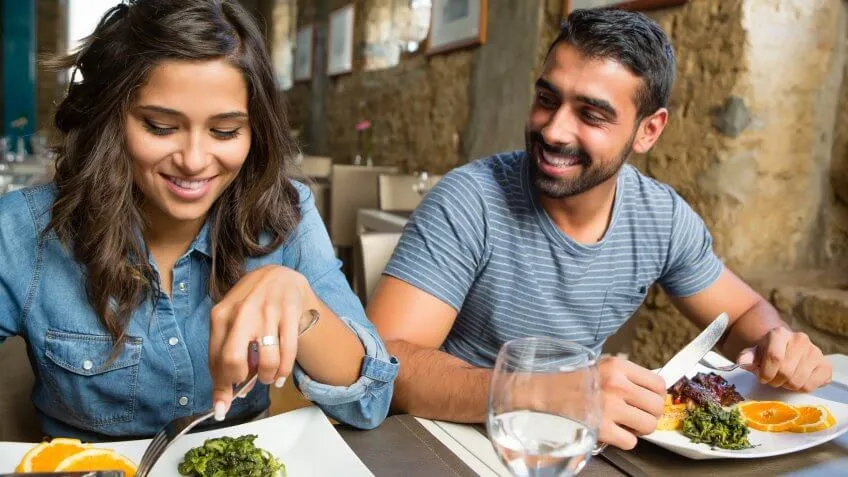 happy young couple eating at a restaurant