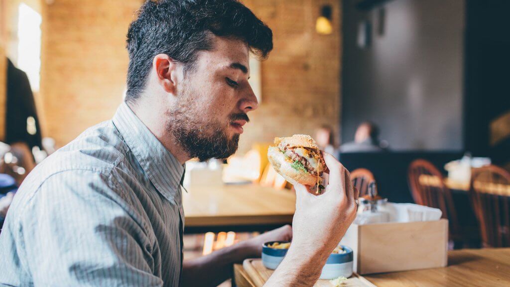 Identify Expenses You Can Cut man eating a burger