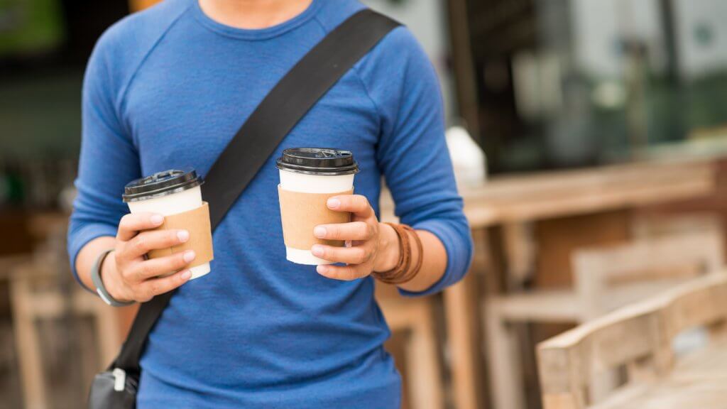 Enjoy Little Luxuries Without Hurting Your Finances man holding two cups of coffee