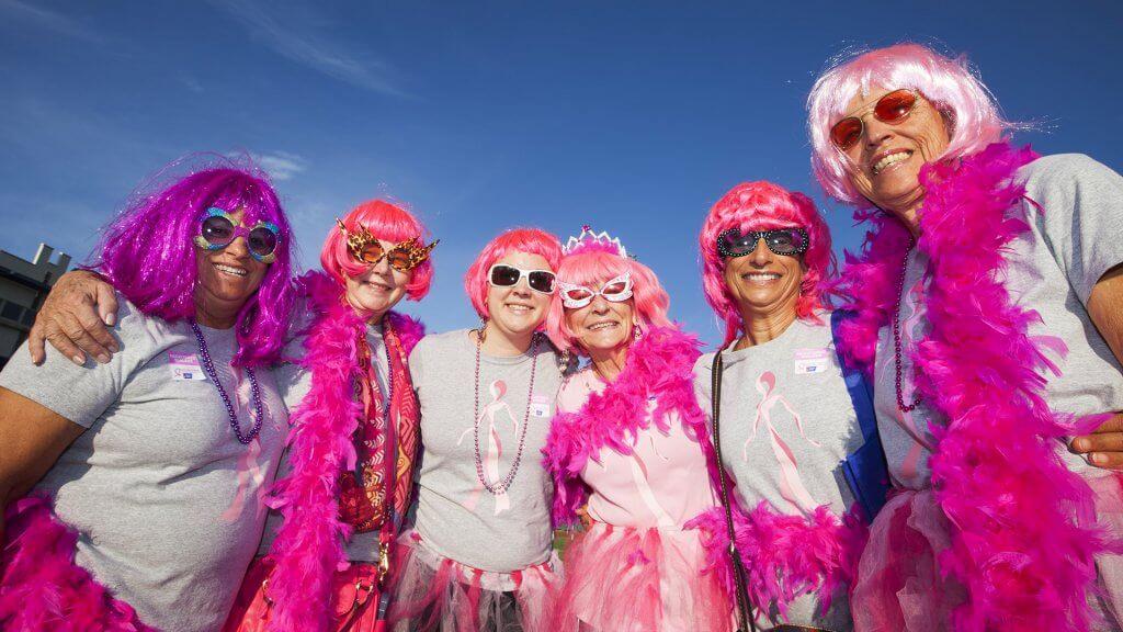 group of women dressed in garish pink wigs and accessories