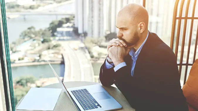 man in suit thinking deeply at desk